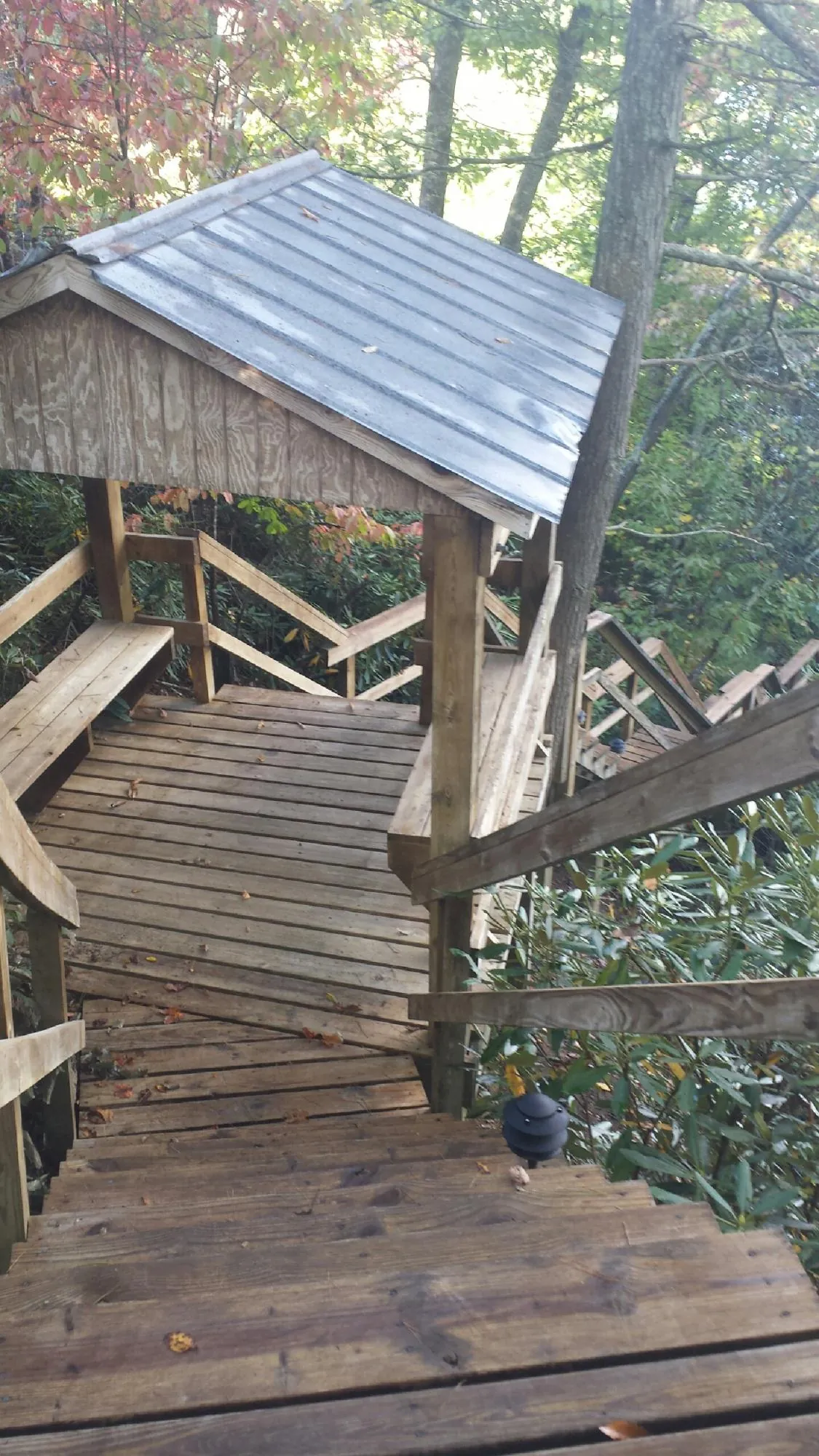 Metal roofed shelter over wooden steps on a wooded walkway — Skylight Repair & Installation work by our crew in Muskego