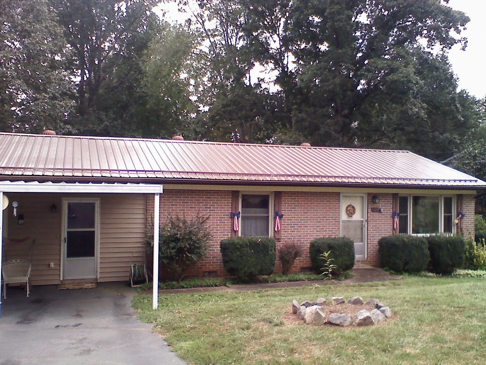 Bronze metal roof and carport on a brick ranch home — Roof Repair work by our crew in Muskego