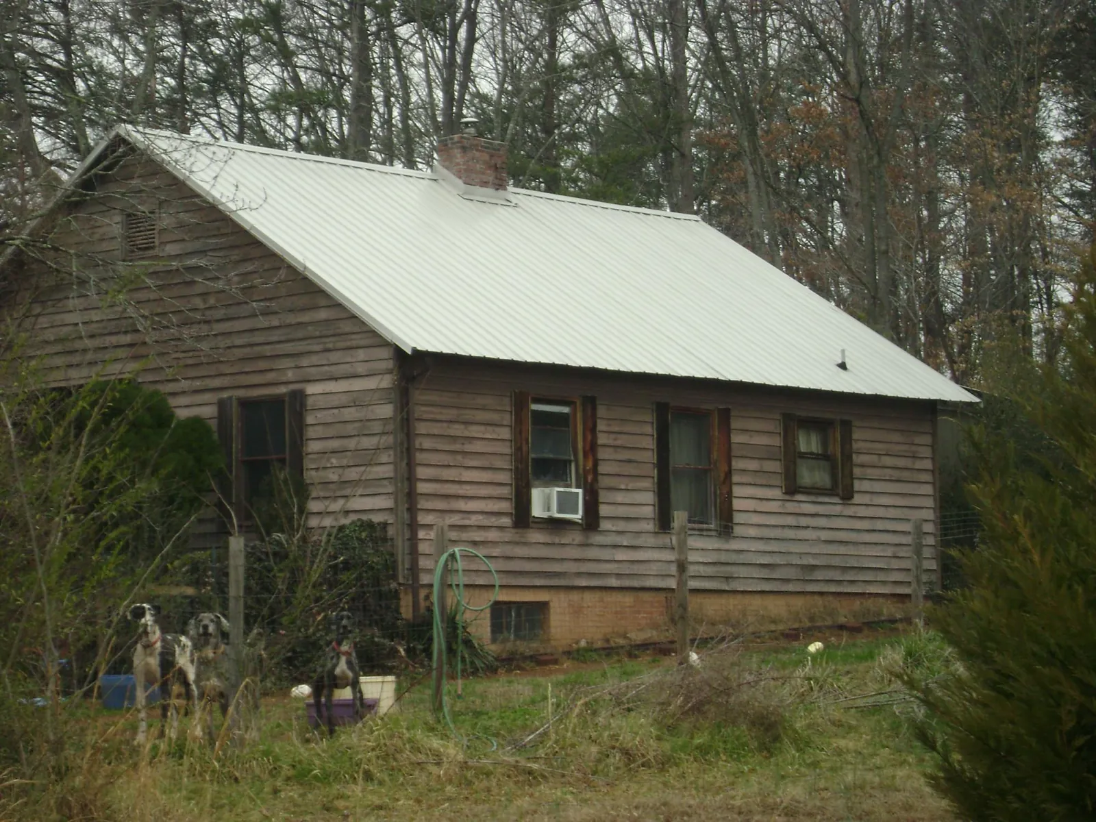 White metal roof on an old wood sided farmhouse, from a Metal Roof Installation job in Muskego